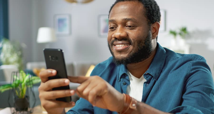 Man sitting down interacting with an app on his cell phone